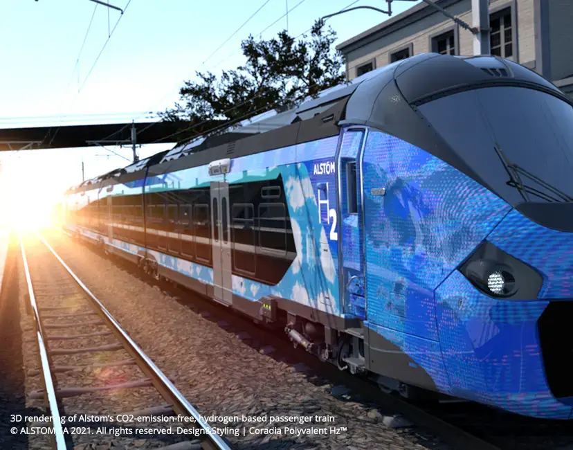 Ein eleganter, blauer Personenzug mit Wasserstoffantrieb an einem Bahnhof, im Hintergrund scheint Sonnenlicht.